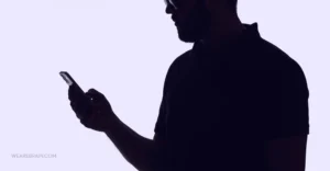 Shadow of a man using his phone
