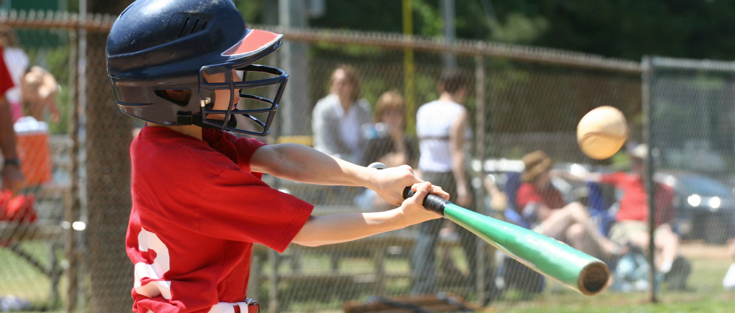 A kid hitting a baseball