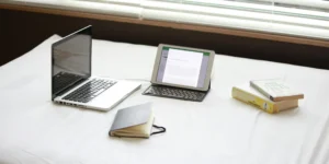 Laptop, tablet , and books on the bed