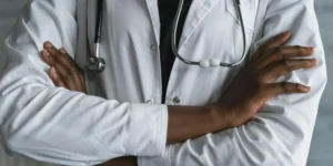 Photo of a healthcare professional, just his arms folded in front a stethoscope