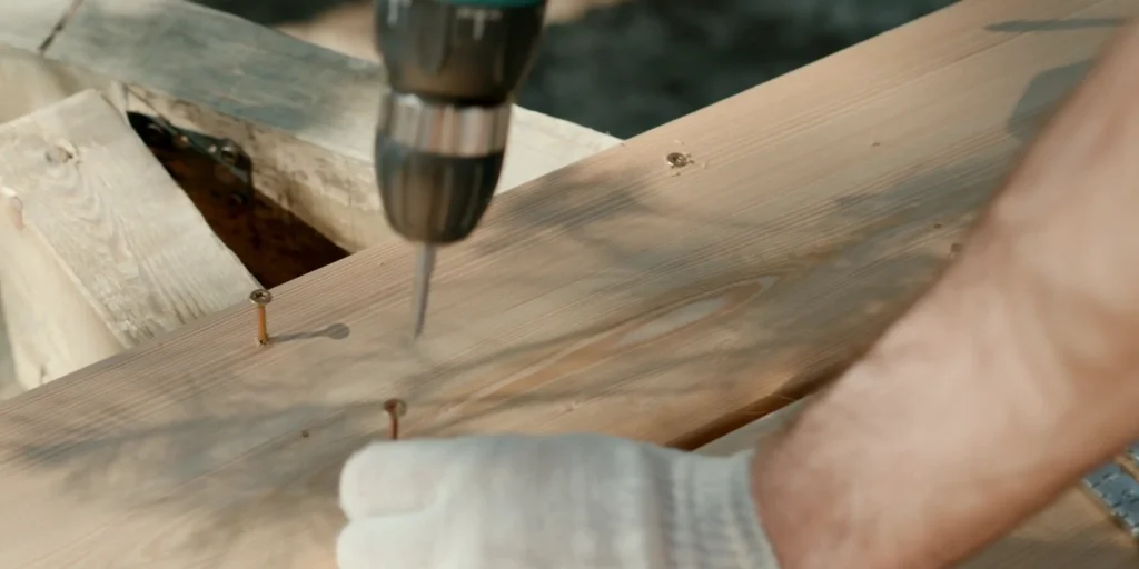 man drilling the wood close-up