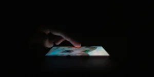 Finger touching the phone screen in the dark