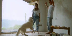young couple dancing with dog amidst revovation