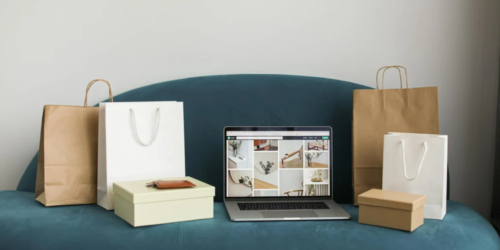Photo of shopping bags and an open laptop on a sofa