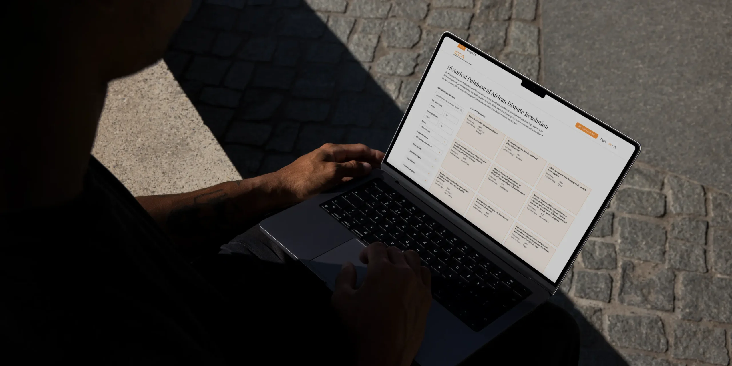 Person holding a laptop with ICCA website