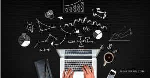 Picture of a person typing on a laptop, with different graphs around it