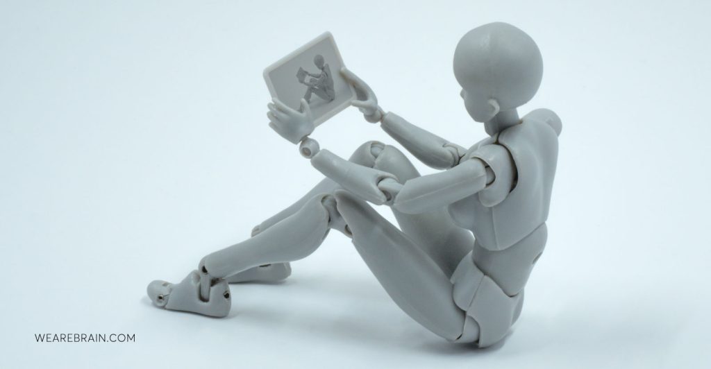 A figurine looking at a tablet