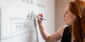 Person writing on a white board