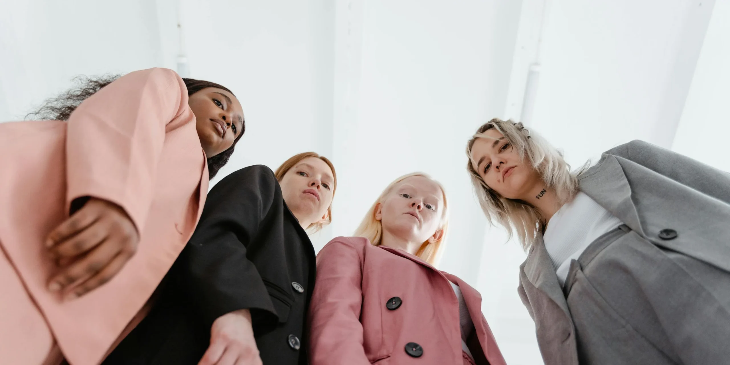 Photo of four young business women looking seriously into the camera