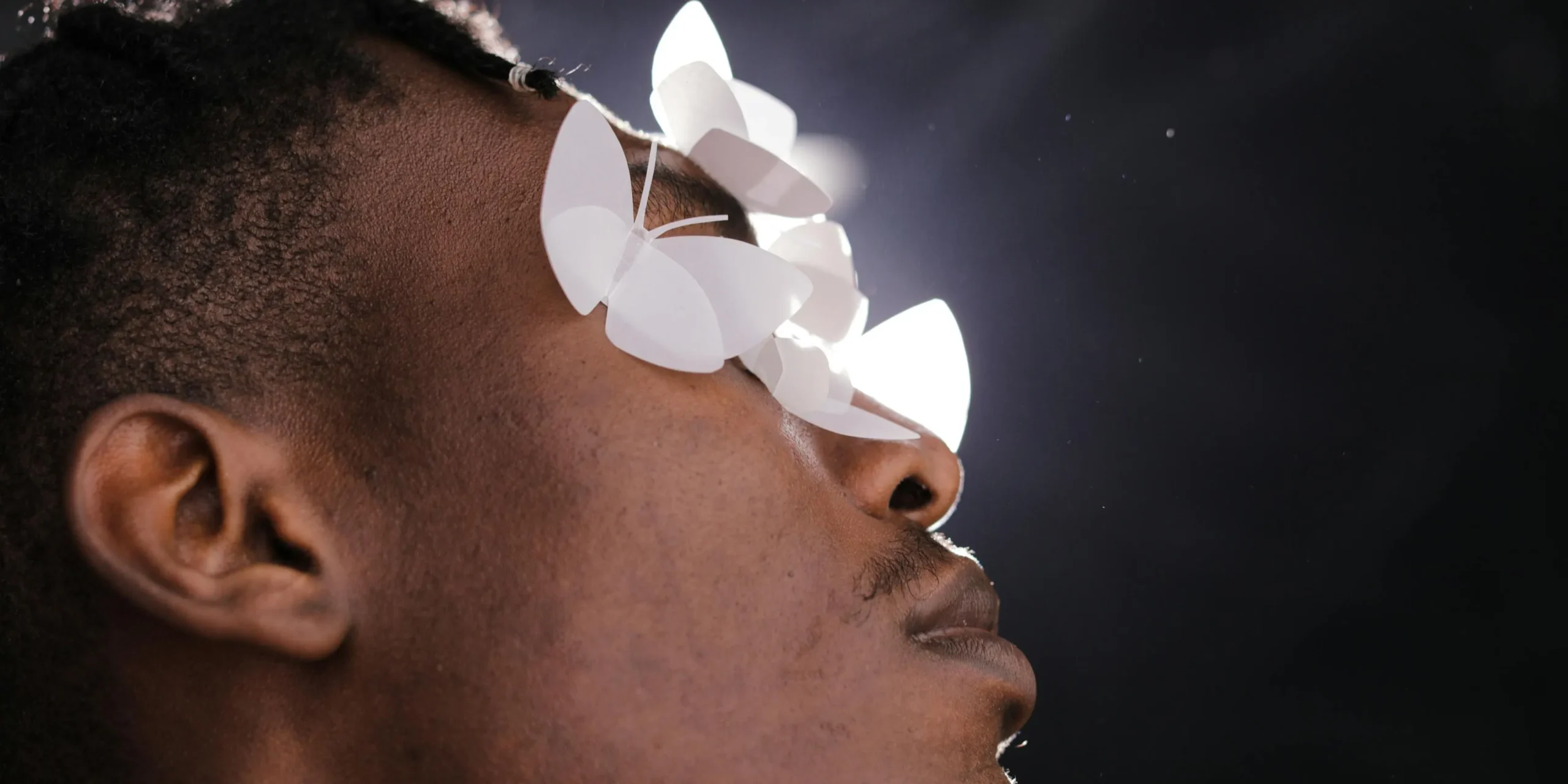 Photograph of a man with paper butterflies on his face
