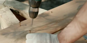 man's hand drilling the wood close-up