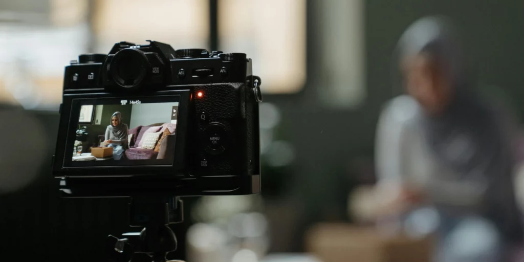 Photo of a person being filmed with a DSLR