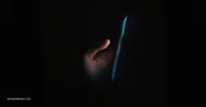 Hand holding a phone in the dark