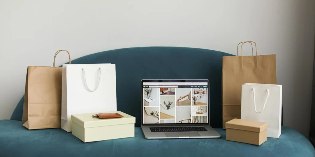 Photo of shopping bags and an open laptop on a sofa