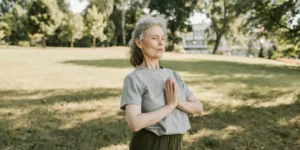 Woman in Namaste position in a park