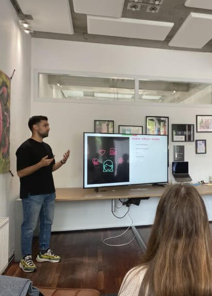 Omar M'sadek presenting in front a large screen