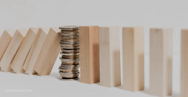 Pile of coins stopping fallen wooden pieces