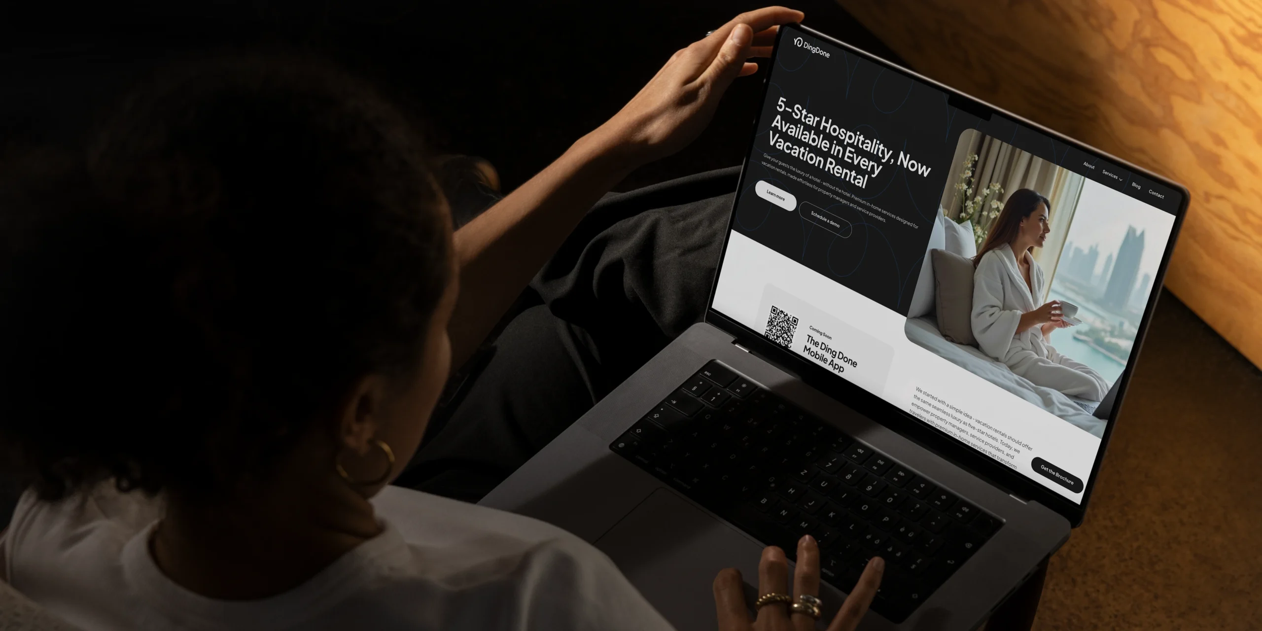 Woman is holding laptop with the DingDone website