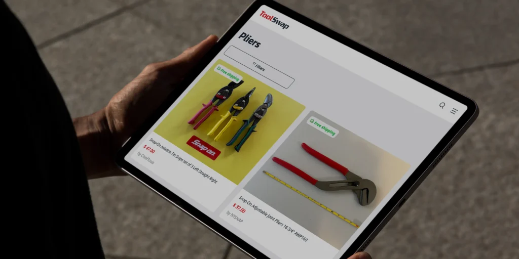 Men's hands holding aa tablet with ToolSwap website