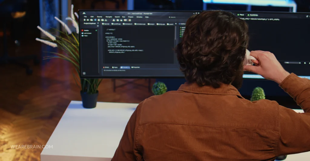man is looking at the computer-view from the back