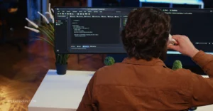 man is looking at the computer-view from the back