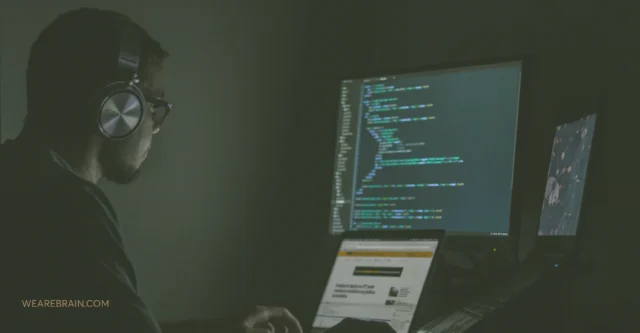 A developer coding in a black room